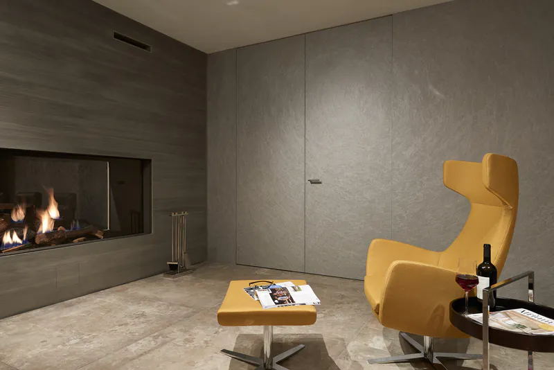 innentuer-grauthoff-holz-disselnmeyer-aa740efa Moderne, flächenbündige Grauthoff Innentür in einem Wohnraum mit Kamin und gelbem Sessel.